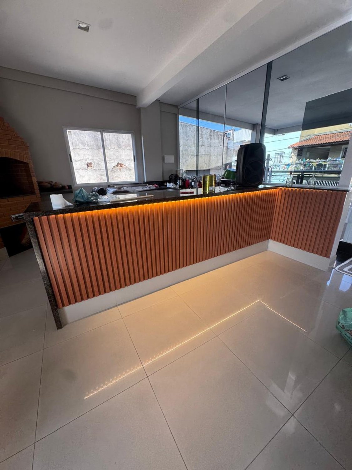 Balcão ripado de madeira com fita de LED no espaço gourmet
